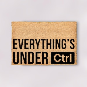 May include: A brown doormat with the text "Everything's Under Ctrl" in black lettering.