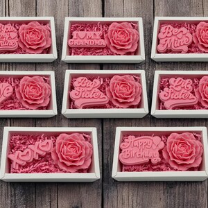 a set of six pink roses in a white box