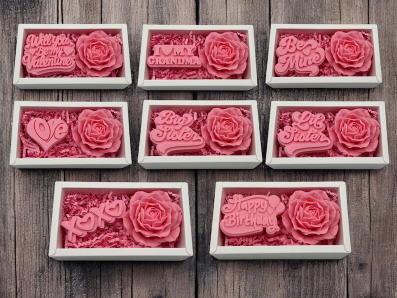 a set of six pink roses in a white box