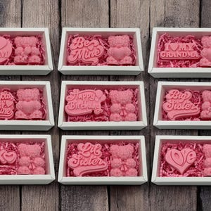 a bunch of pink candies in a white box