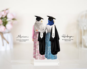 May include: Two women in graduation gowns and caps stand back to back. The woman on the left is wearing a pink and white patterned dress and a white hijab. The woman on the right is wearing a blue and white patterned dress and a blue hijab. The text "Meriem" is written above the woman on the left, and the text "Hidaya" is written above the woman on the right. The text "University of Nottingham Class of 2023" is written below the woman on the left, and the text "Birmingham University Class of 2023" is written below the woman on the right.