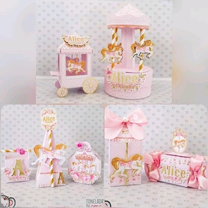 Pode incluir: Caixas de lembrancinhas de festa rosa e dourado com tema de carrossel com o nome "Alice" nelas. As caixas são decoradas com cavalos, flores e um carrossel.