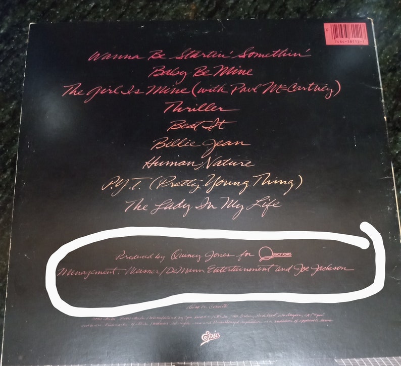 May include: Black and white album cover with the title "Thriller" by Michael Jackson. The album cover features a red handwritten list of songs including "Wanna Be Startin' Somethin'," "Baby Be Mine," "The Girl Is Mine (with Paul McCartney)," "Thriller," "Beat It," "Billie Jean," "Human Nature," "P.Y.T. (Pretty Young Thing)," and "The Lady In My Life." The album cover also includes the text "Produced by Quincy Jones for Qwest Records" and "Management: Meiner/Deben Entertainment and Joe Jackson."