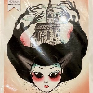 May include: A black and white illustration of a haunted house with a woman's face in the foreground. The house is surrounded by shadowy hands. The text "Haunted House" is at the bottom of the image.