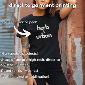 Pode incluir: Uma camiseta preta com o texto "herb & urban" impresso em branco. A camiseta est&aacute; sendo usada por uma pessoa em p&eacute; na frente de uma parede de tijolos. O texto "direct to garment printing" est&aacute; no topo da imagem. O texto "Will not crack or peel!" est&aacute; no canto superior esquerdo da imagem. O texto "High quality products!" est&aacute; no canto inferior esquerdo da imagem. O texto "State of the art, high tech, direct to garment printing!" est&aacute; no canto inferior esquerdo da imagem. O texto "Rated for 50+ washes!" est&aacute; no canto inferior esquerdo da imagem. O texto "No shiny vinyl or sublimation!" est&aacute; no canto inferior esquerdo da imagem.