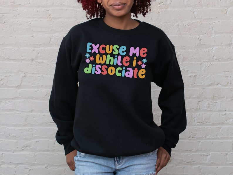 May include: Black sweatshirt with the text "Excuse me while I dissociate" in colourful letters with small flower accents.