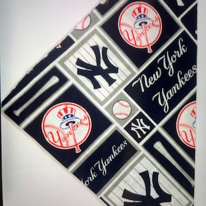May include: A blue and white bandana with a repeated pattern of the New York Yankees logo, baseballs, bats, and the words "New York Yankees".