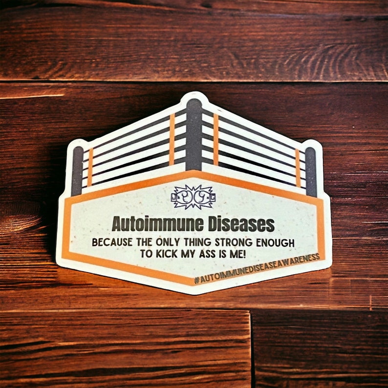 Peut inclure: Un autocollant avec un graphique de ring de lutte et le texte "Autoimmune Diseases Because the only thing strong enough to kick my ass is me! #AutoimmuneDiseaseAwareness".