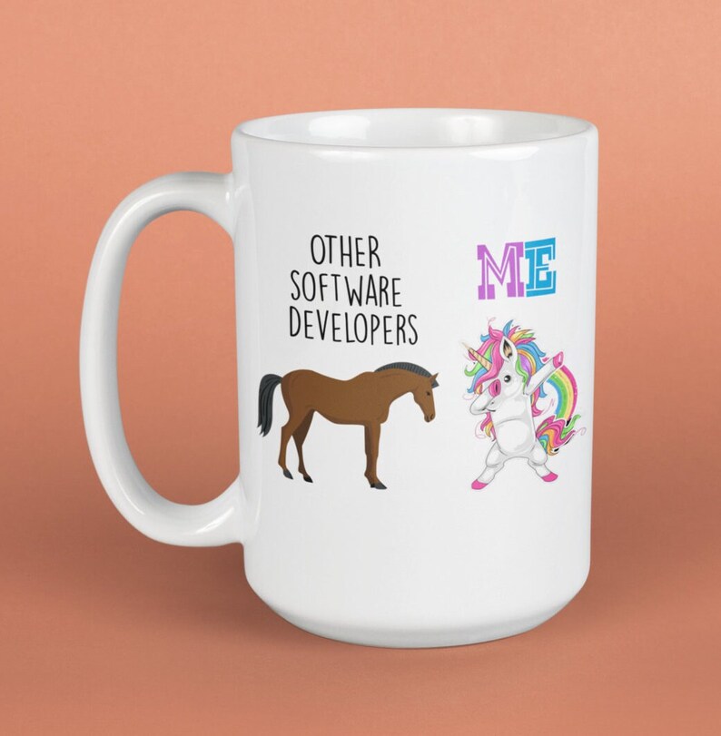 May include: White ceramic mug with a brown horse and a rainbow unicorn. The text on the mug reads "Other Software Developers" and "ME".