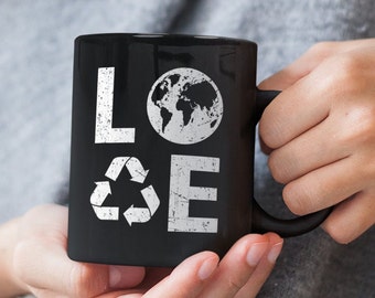 May include: Black ceramic mug with a white graphic design that says "LOVE" with a recycle symbol and a globe in the design.