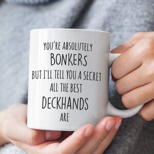 May include: White ceramic mug with black text that reads "You're absolutely bonkers but I'll tell you a secret all the best deckhands are."