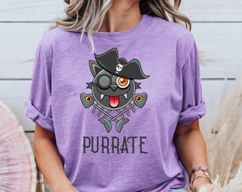 May include: Purple t-shirt with a black cat wearing a pirate hat and holding crossed bones. The cat has a single eye patch and a tongue sticking out. The text "PURRATE" is printed below the cat.