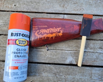 May include: A can of orange Rust-Oleum Stops Rust Gloss Protective Enamel spray paint with the text "That's cool now Spray Paint It" written in orange paint on a wooden surface.