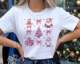 May include: White t-shirt with a pink Christmas design. The design features a gingerbread man, Santa Claus, a Christmas tree, presents, and a gnome. All of the elements are surrounded by pink bows and stars.