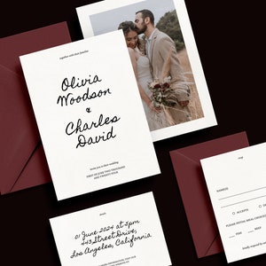 Op de afbeelding: Een witte huwelijksuitnodiging met zwarte kalligrafietekst. De uitnodiging luidt "Olivia Woodson & Charles David" en bevat de datum en locatie van de bruiloft. Een kleinere witte kaart met zwarte tekst luidt "RSVP" en bevat een ruimte voor gasten om hun namen en maaltijdkeuzes te vermelden. De uitnodiging bevindt zich op een bordeauxrode achtergrond.
