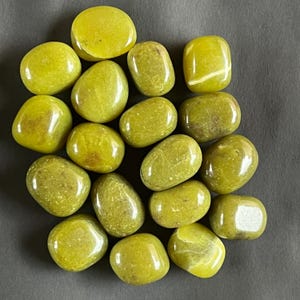 Pode incluir: Uma coleção de pedras lisas e polidas de aventurina verde. As pedras são de vários tons de verde, algumas com um brilho leve.