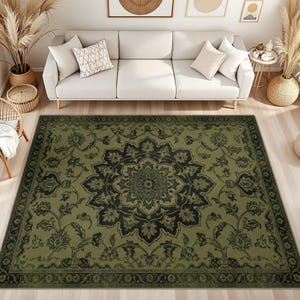 May include: A rectangular area rug featuring a large, dark green and black central floral medallion pattern. The design includes intricate botanical motifs and scrolling vines, framed by a wide, decorative border in matching dark tones.