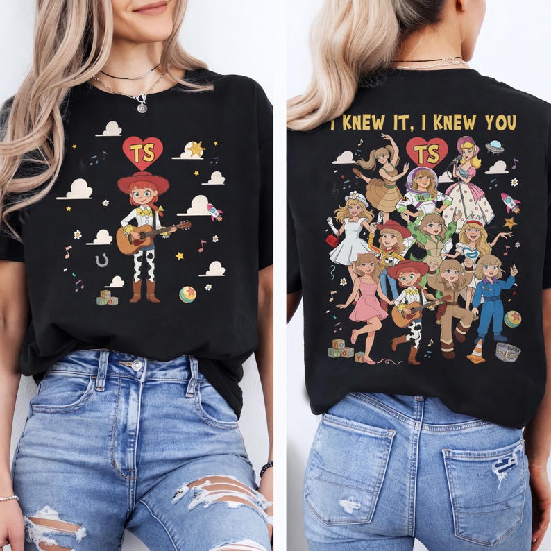 May include: A black t-shirt featuring a front graphic of a cowgirl character playing a guitar with a heart containing the letters TS. The back graphic displays multiple female characters in various outfits, the text I KNEW IT, I KNEW YOU, and a heart with TS.