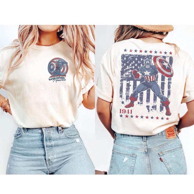 May include: A cream-colored short-sleeve t-shirt featuring a small Captain America circular logo on the front left chest. The back displays a large graphic of Captain America with a shield over a distressed American flag and the text 1941.