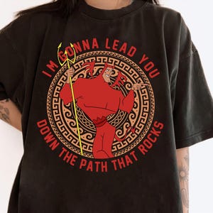 May include: Black t-shirt with a red and yellow graphic of a devil character holding a trident. The graphic includes the text "I'm gonna lead you down the path that rocks".