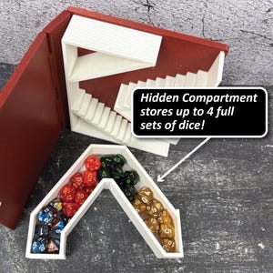 May include: A red and white dice storage box with a hidden compartment. The box is open, revealing a white interior with a staircase design. The box contains multiple sets of dice in various colors. Text on the image reads: "Hidden Compartment stores up to 4 full sets of dice!"
