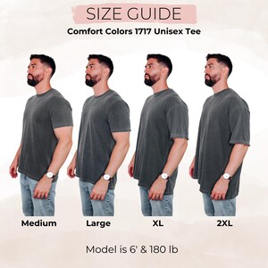 May include: Size guide for Comfort Colors 1717 Unisex Tee. Four models wearing the tee in sizes Medium, Large, XL, and 2XL. The model is 6' and 180 lb. The tee is a dark gray color.