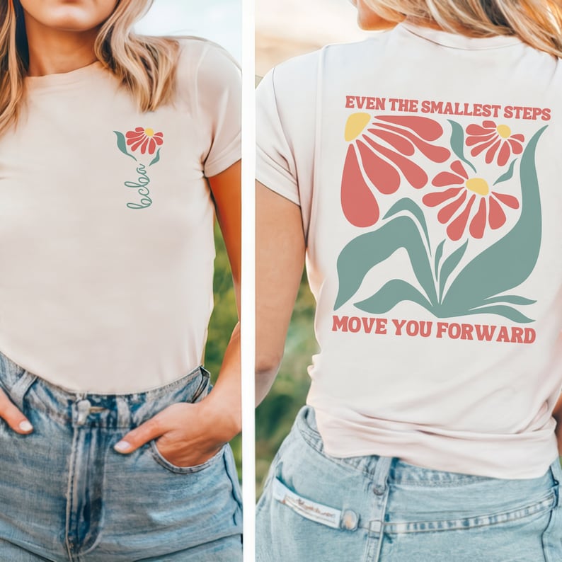 May include: A light pink t-shirt with a floral design and the text "Even the smallest steps move you forward".