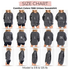 Puede incluir: Tabla de tallas para la sudadera unisex Comfort Colors 1566. La tabla muestra las medidas para las tallas S, M, L, XL y 2XL. La modelo mide 173 cm y pesa 57 kg.