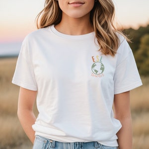 May include: White t-shirt with a colorful graphic of a globe and the text "ESL teacher" on the front.