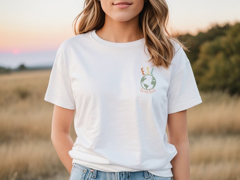 May include: White t-shirt with a colorful graphic of a globe and the text "ESL teacher" on the front.