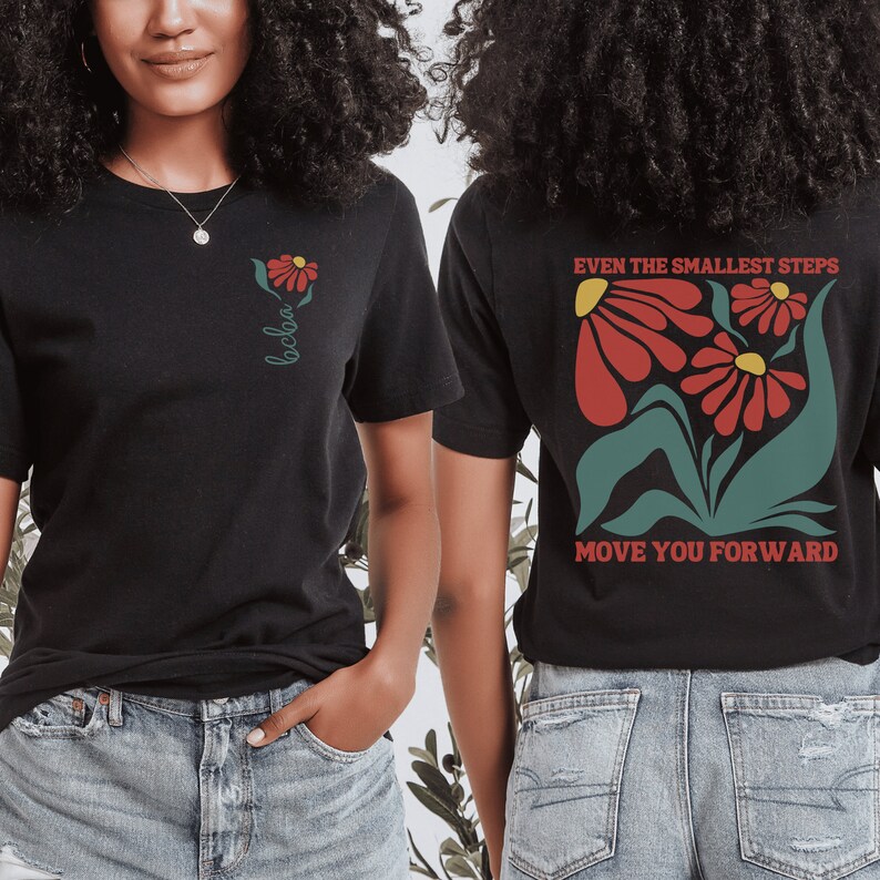 May include: Two black t-shirts with a floral design and text. The front shirt has a single flower with the word "bebo" written below it. The back shirt has a larger floral design with the text "Even the smallest steps move you forward".