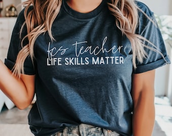 May include: A navy blue t-shirt with white text that reads "FCS Teacher Life Skills Matter".