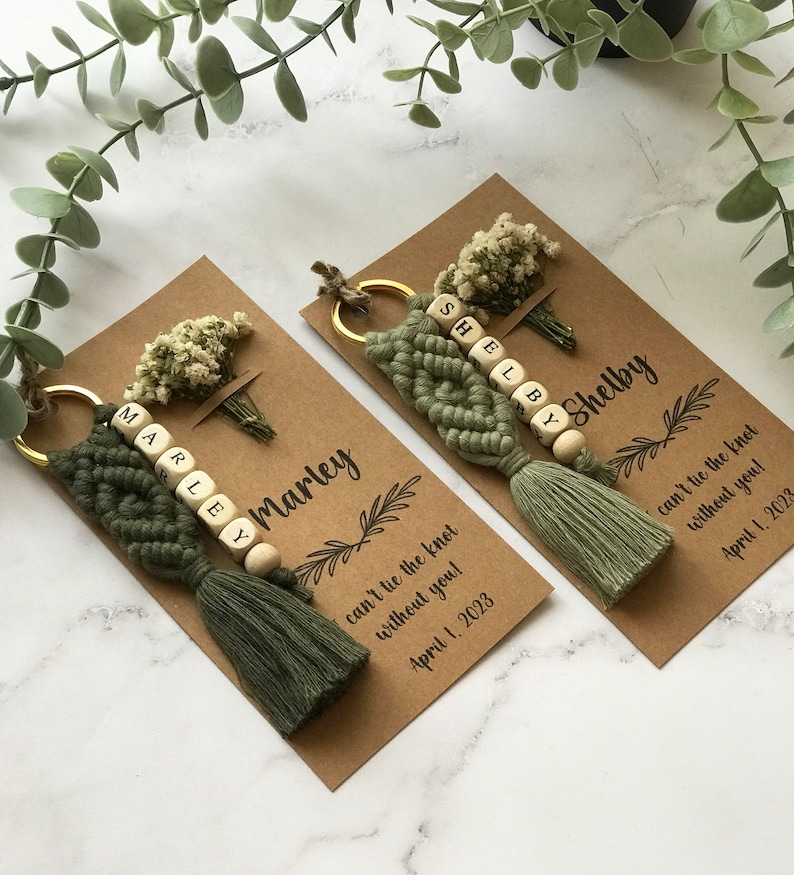 The macrame keychain is attached to a personalizable card. There are real flowers on the card.