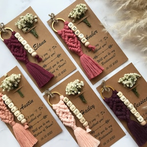 The macrame keychain is attached to a personalizable card. There are real flowers on the card.