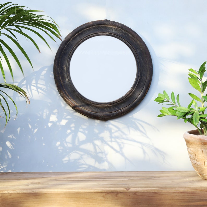 Handcrafted round mirror with a reclaimed teak wood frame and smoky black finish, featuring rounded edges and natural wood character. Rustic wall mirror for bedroom, bathroom, living room or entryway. Reclaimed teak mirror, round wooden mirror, black wood mirror, handmade wall decor, rustic home decor, sustainable wood furniture, artisan-crafted mirror.
