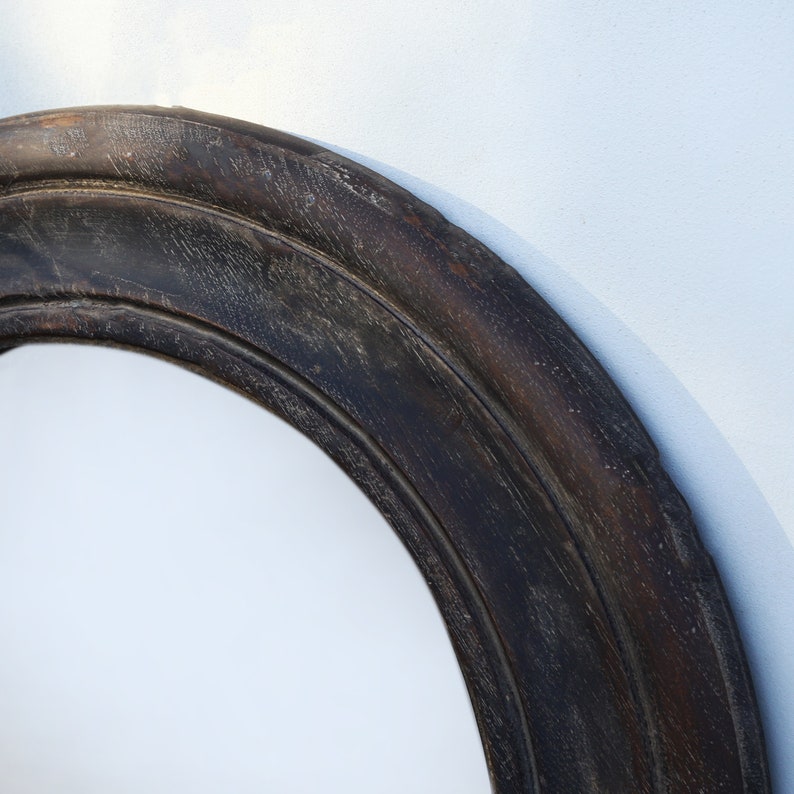 Handcrafted round mirror with a reclaimed teak wood frame and smoky black finish, featuring rounded edges and natural wood character. Rustic wall mirror for bedroom, bathroom, living room or entryway. Reclaimed teak mirror, round wooden mirror, black wood mirror, handmade wall decor, rustic home decor, sustainable wood furniture, artisan-crafted mirror.