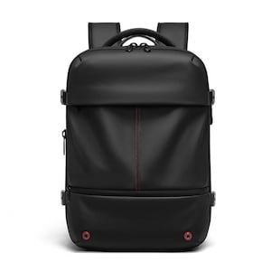 Könnte beinhalten: Schwarzer Rucksack mit einem schlanken, modernen Design. Er verfügt über einen oberen Griff, verstellbare Schultergurte und mehrere Fächer. Ein vertikales rotes Nahtdetail verläuft durch die Mitte. Enthält rote kreisförmige Akzente unten.
