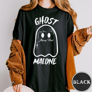 May include: Black t-shirt with a white ghost graphic. The ghost has the text "Stay Away Always Tired" and the word "GHOST" is above the ghost and the word "MALONE" is below the ghost.