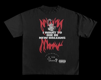 May include: Black t-shirt with a graphic design featuring the text "I WANT TO DIE IN NEW ORLEANS" in white, with red flames and a stylized image. The shirt also includes the text "SUICIDEBOYS" and a parental advisory warning.