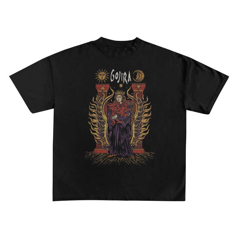 May include: Black t-shirt featuring a graphic of a robed figure with a crown, holding a snake, and surrounded by flames. The word "GOJIRA" is above the figure, with sun and moon symbols on either side. The design is in shades of red, purple, and gold.