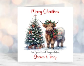 Puede incluir: Una tarjeta de Navidad con una vaca de las tierras altas que lleva una bufanda de tartán rojo y verde y una corona de acebo. La vaca está de pie junto a un árbol de Navidad decorado con regalos debajo. La tarjeta dice "Feliz Navidad" y "Para un hijo y una nuera muy especiales Darren & Tracy".