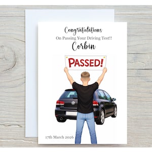 May include: A greeting card featuring a black Volkswagen Golf car and a person seen from behind wearing a black t-shirt and blue jeans, holding a sign that says PASSED!. The text reads Congratulations On Passing Your Driving Test!! Corbin 17th March 2026.