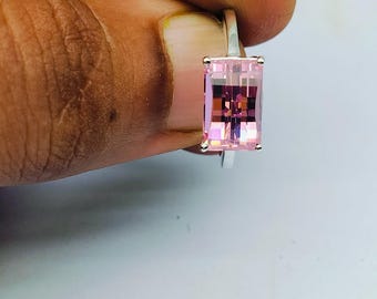 May include: A silver ring with a pink rectangular gemstone.