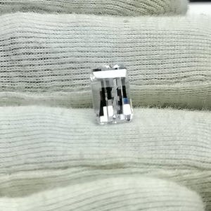 May include: A clear, rectangular, faceted gemstone with a slight blue hue.