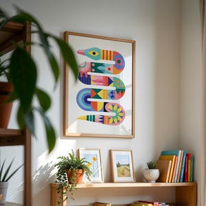 May include: A framed wall art print featuring a stylised, multi-coloured snake illustration with geometric patterns in shades of teal, pink, yellow, orange, and blue. The artwork is displayed in a light wood frame on a white wall above a wooden shelf.