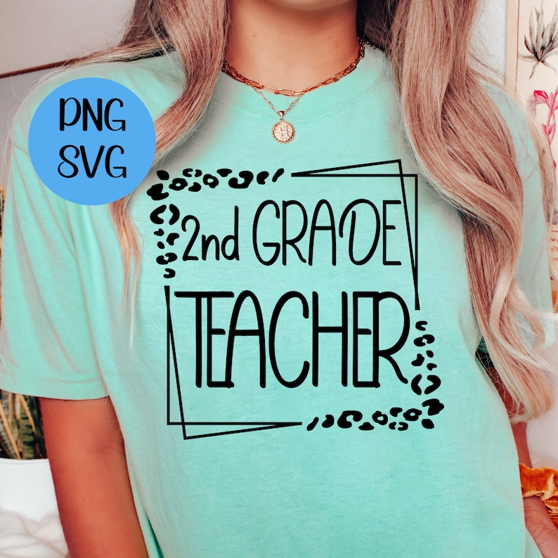 Pu&ograve; includere: Una maglietta blu turchese con il testo "2nd GRADE TEACHER" in una cornice rettangolare nera con accenti leopardati.