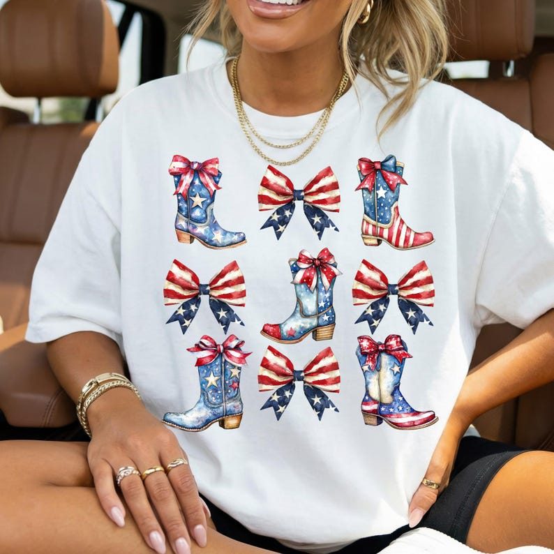 May include: White t-shirt featuring a patriotic design of cowboy boots and bows in red, white, and blue. The boots have stars and stripes, and the bows have American flag patterns. The design is repeated across the shirt.