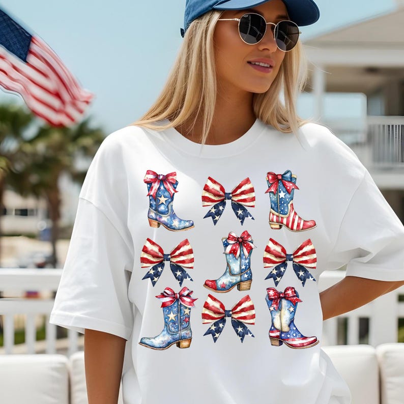 May include: White t-shirt featuring a patriotic design of cowboy boots and bows in red, white, and blue. The boots have stars and stripes, and the bows have a similar pattern. The design is repeated across the shirt.