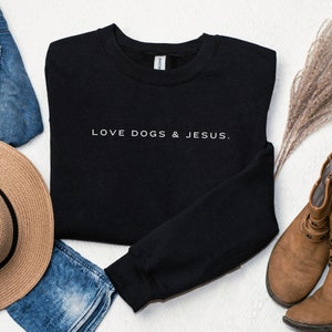May include: Black sweatshirt with the text "LOVE DOGS & JESUS." printed in white on the front.