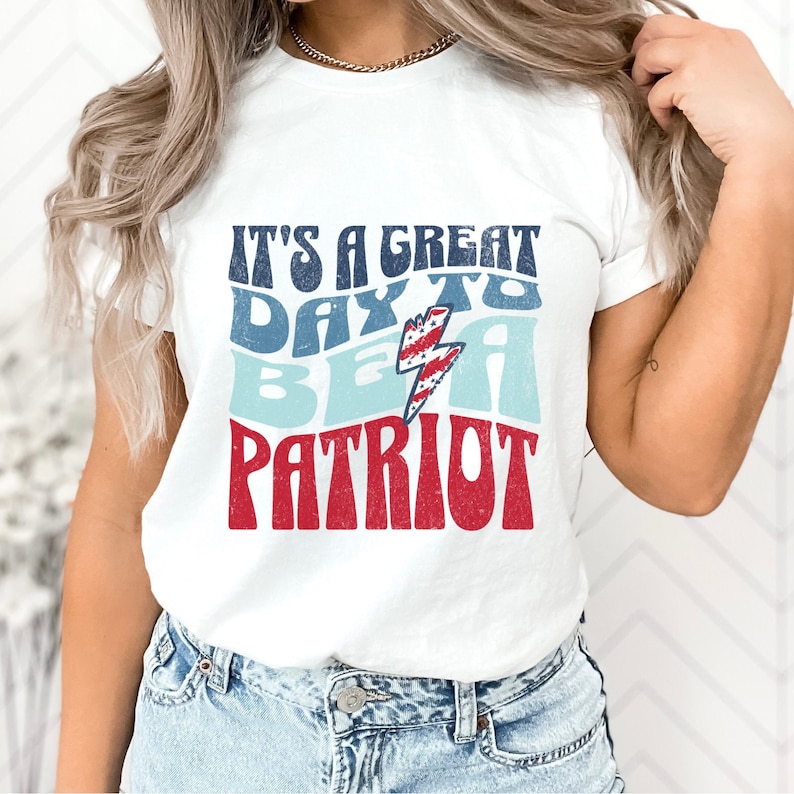 May include: White t-shirt with a red, white and blue graphic that says "It's a great day to be a patriot".